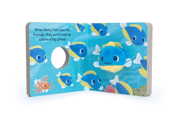 The "Baby Fish (Finger Puppet Book)" is a children's board book featuring vibrant illustrations of blue and yellow fish swimming. A plush Baby Fish finger puppet is set into the right page. The text reads: “When Baby Fish sees his friends, they swim side by side in a big group.”