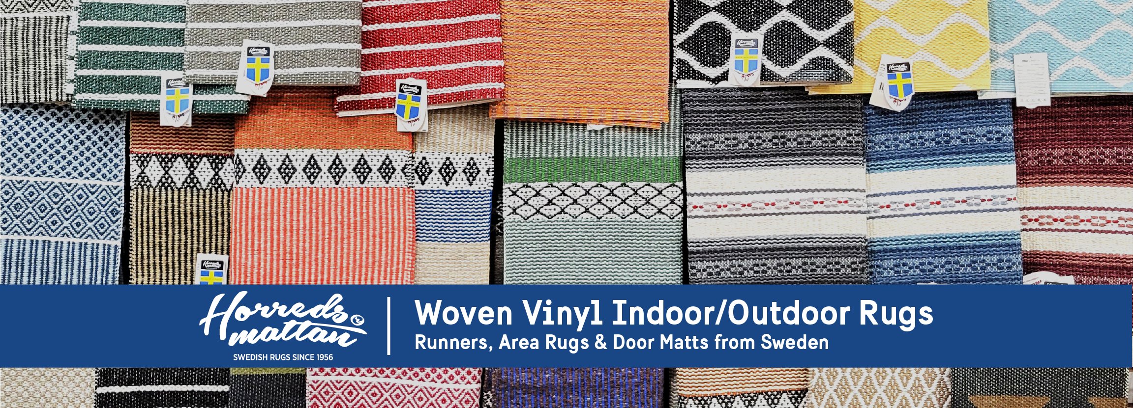 A display of various colorful woven rugs with different patterns and textures hanging on a wall.