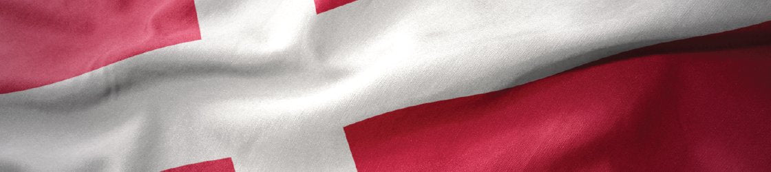 A close-up view of the Danish flag, featuring a red background and a white Scandinavian cross.