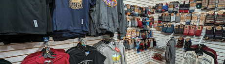Clothing store display featuring hoodies on hangers and a variety of socks on a wall rack.