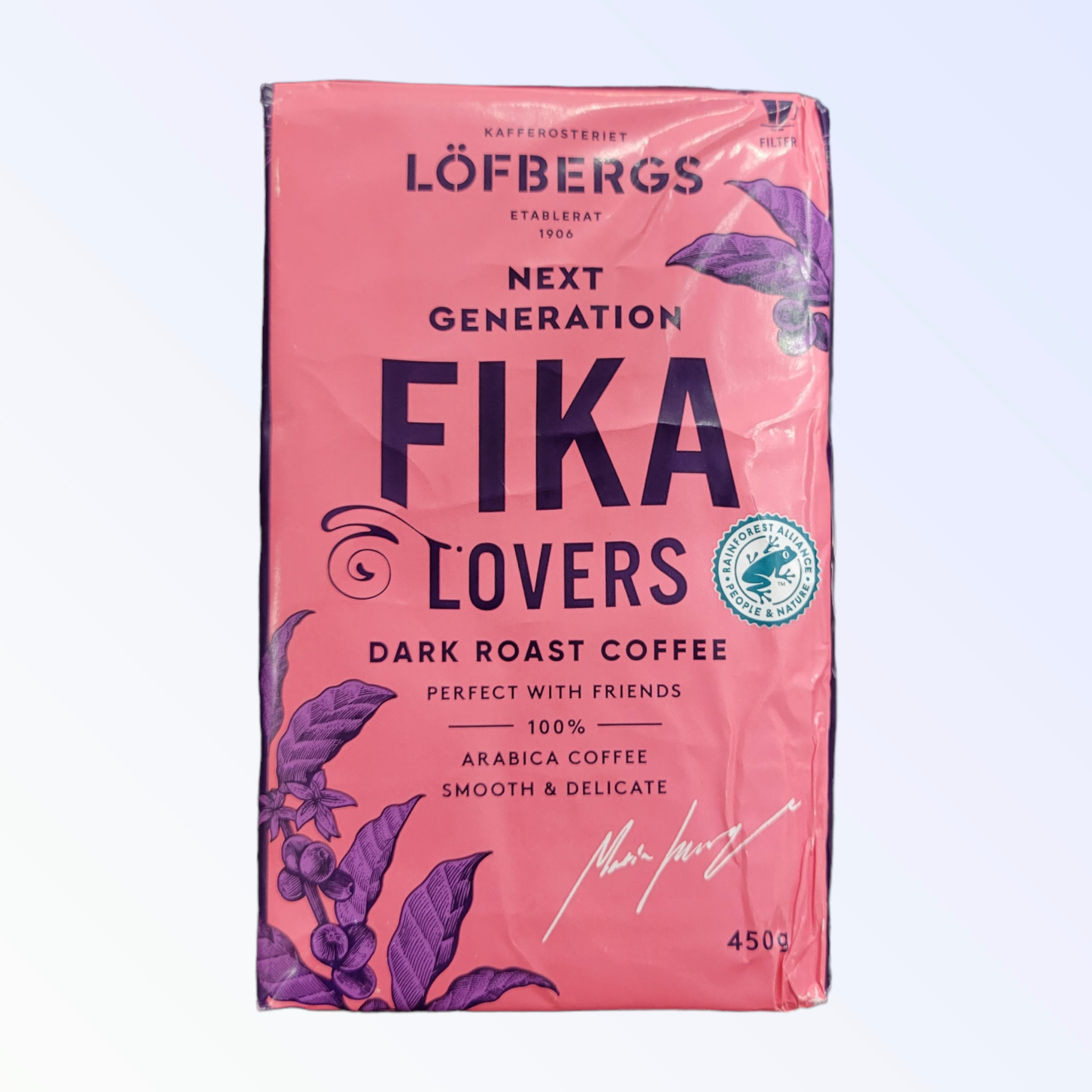 Pink coffee bag labeled Löfbergs Fika Lovers Dark Roast Coffee, with berry and leaf illustrations. Contains 450g of Arabica coffee, described as smooth and delicate.