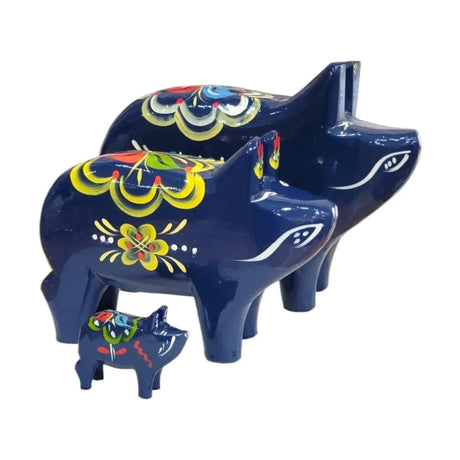 A row of colorful painted horse figurines on a blue shelf, featuring black, blue, and red colors with decorative patterns.