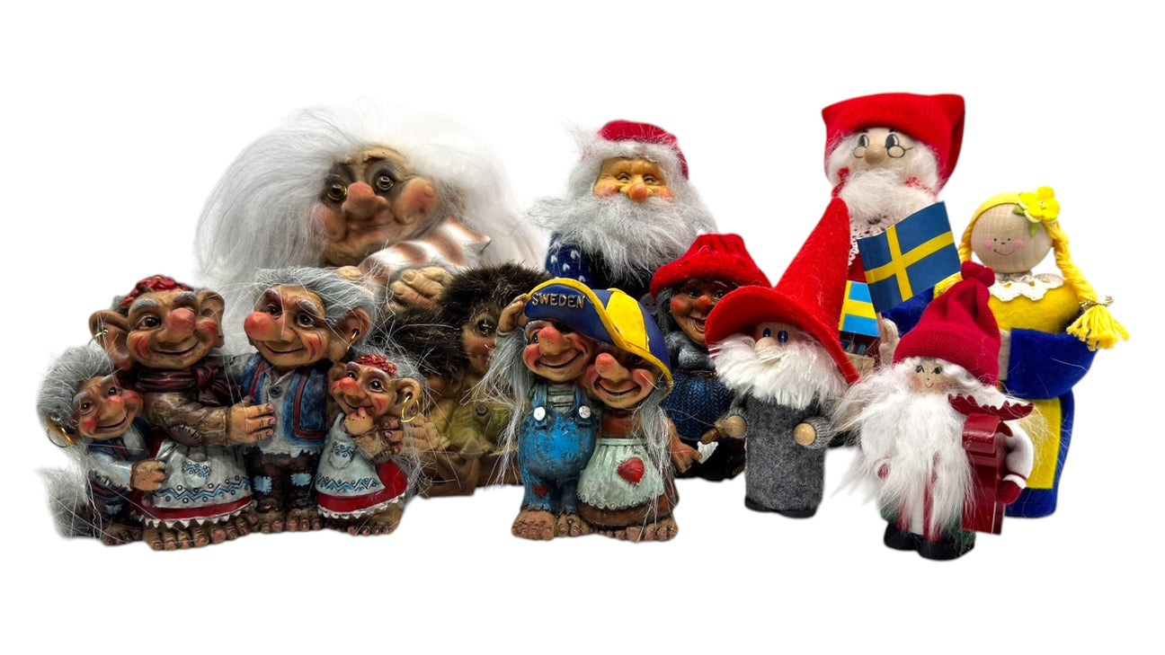 A group of colorful Scandinavian troll and gnome figurines, including some dressed in Swedish-themed outfits, arranged together on a white background.