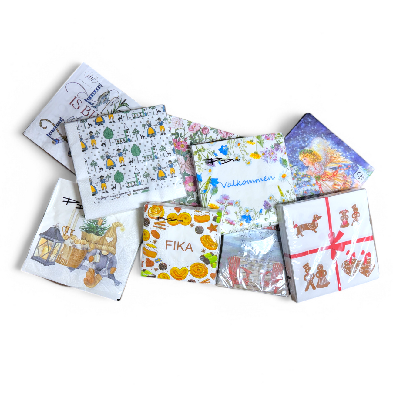 An assortment of decorative paper napkins with various designs, including floral, festive, food-themed, and cityscape patterns, arranged on a white surface.