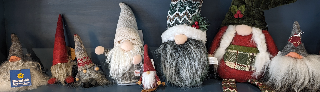 A shelf displaying various gnome figurines with beards and hats, including a sign labeled Swedish Gift Shop.