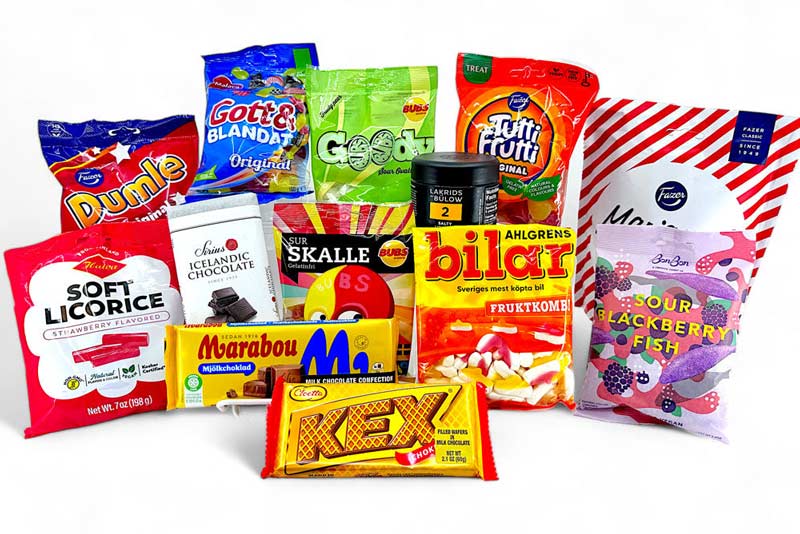 A variety of packaged Scandinavian candies and chocolates, including bags and bars, arranged on a white surface.