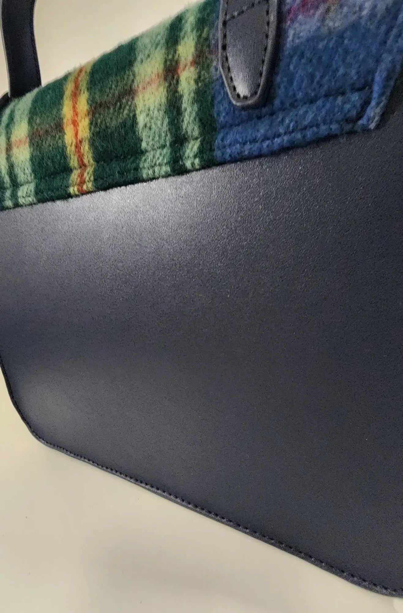 Close-up of the Bag: Nova Scotia Patsy Handbag, featuring a wool body, dark leather bottom, and plaid fabric in green, yellow, and blue.