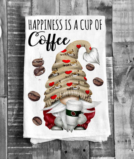 The "Tea Towel: Gnome Happiness is a Cup of Coffee Flour Sack Tea Towel" features a gnome with a coffee cup amid coffee beans and the phrase "Happiness is a cup of coffee" in black script.
