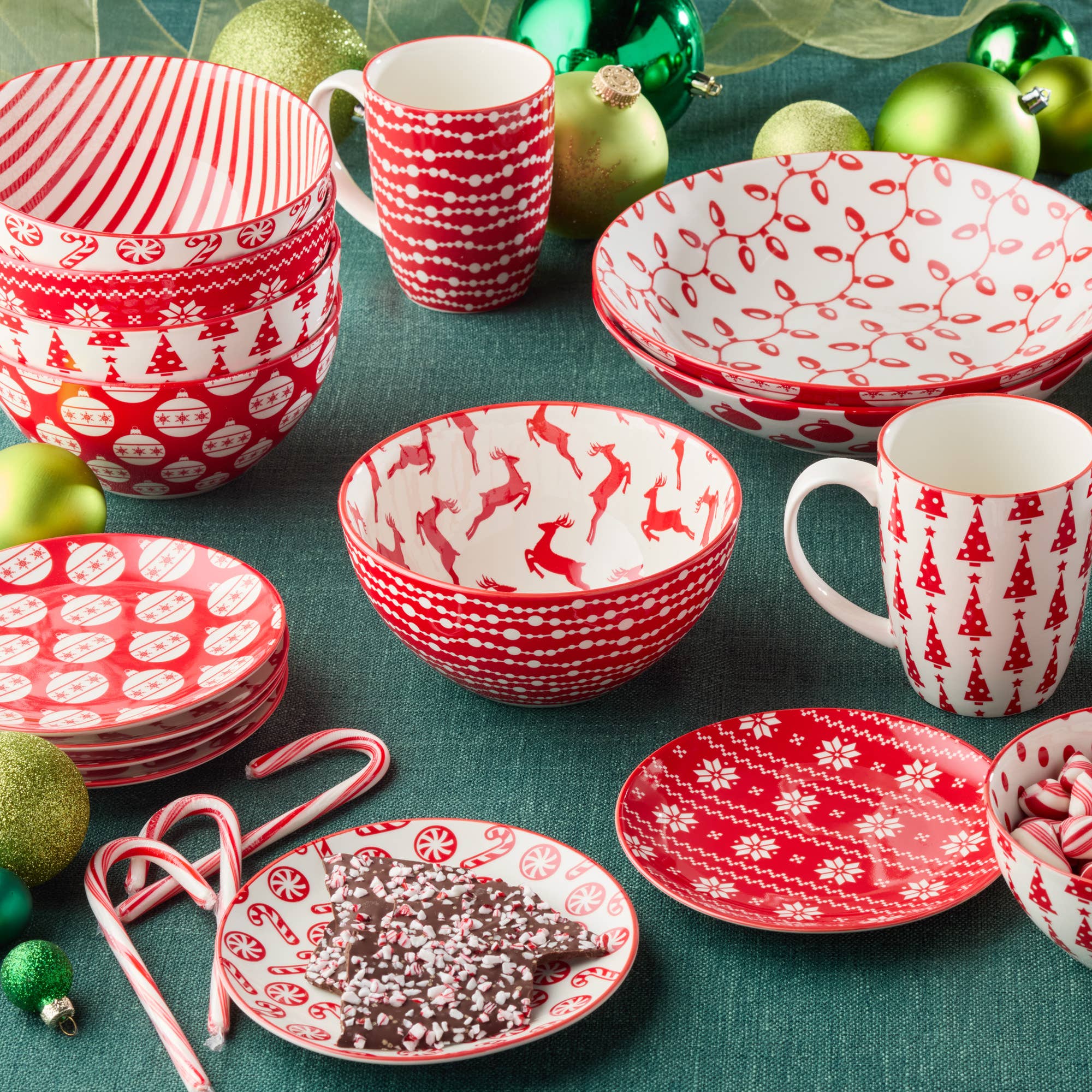 The Peppermint Candy Christmas All Purpose Bowl (4.75x2.25) is displayed with festive patterns, surrounded by green ornaments, candy canes, and chocolate bark on a green tablecloth.