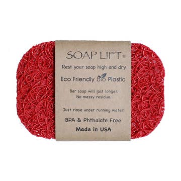 Red oval soap lift made of textured bioplastic with a brown label displaying printed text in multiple lines.