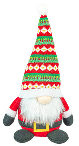 Tomte figure with a long patterned hat, white beard, red outfit, black mittens, and a gold-buckled belt shown sitting upright.