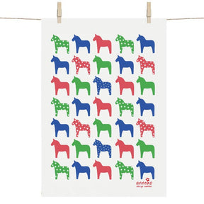 A vibrant display of red, green, and blue stylized Swedish Dala horses with polka dots and solid colors decorates the hanging poster. This piece, reminiscent of the Tea Towel: Dalahäst Classic Swedish Dala Horse by Anneko Design Sweden, adds a vivid touch.