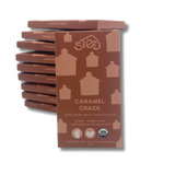 A stack of milk chocolate bars with minimalist brown and tan wrappers, each displaying a simple house-shaped graphic.