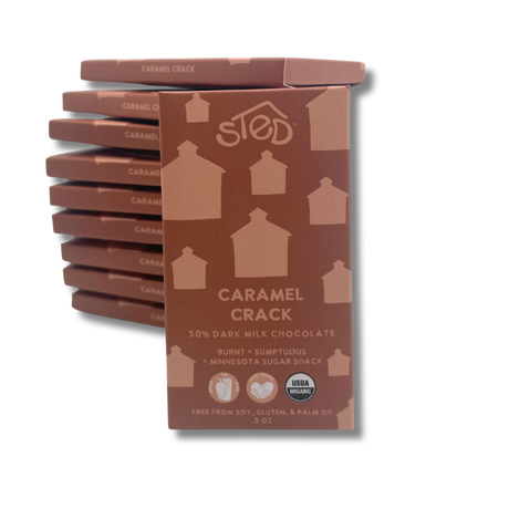 A stack of milk chocolate bars with minimalist brown and tan wrappers, each displaying a simple house-shaped graphic.