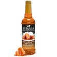 A bottle of Syruvia Syurp: Salted Caramel Syrup Pure Cane Sugar is shown with caramel pieces in front, set against a white background.