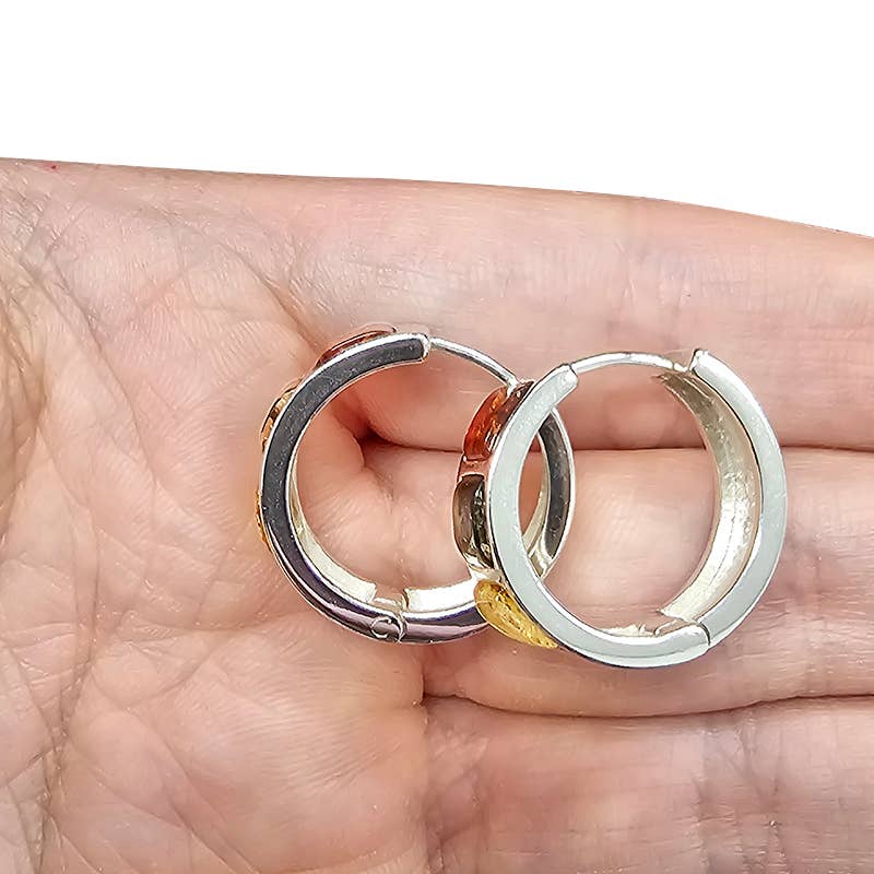 A hand holding two .925 Sterling Silver Hoop Earrings featuring vibrant multicolor stones, including three amber stones.