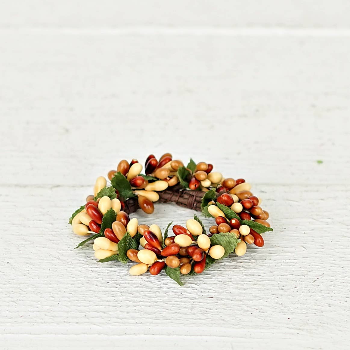 Small taper ring featuring cream, tan, and brown pip berries with green fabric leaves.