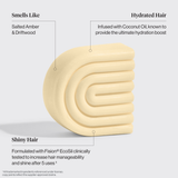 The beige, curved Hair: Coconut Oil Shampoo & Conditioner Bar Combo by Kitsch features a Salted Amber & Driftwood scent, hydrates dry, damaged hair with coconut oil, and adds shine through Fision® EcoSil. Includes two 2.7oz bars.