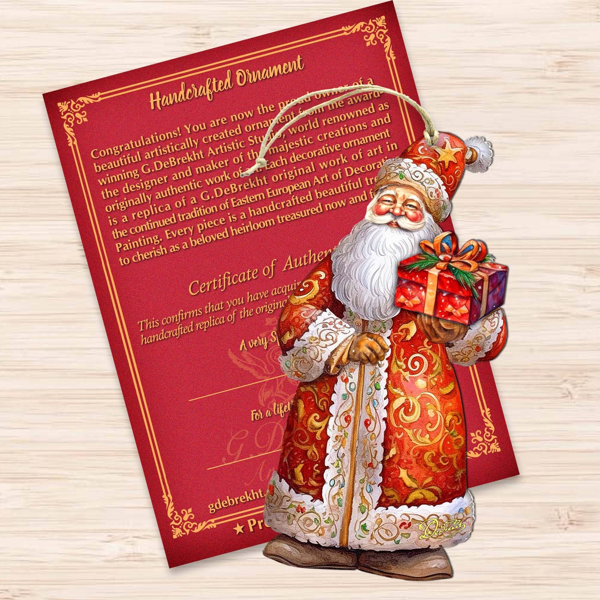 The St. Nick's Gift Wood Ornaments GDebrekht Christmas Santa adds charm to your holiday decor with its vibrant depiction of Santa holding a gift, beautifully complemented by a red and gold Certificate of Authenticity. Pair it with handcrafted wooden ornaments for an extra festive touch.