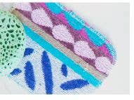 The Euroscrubby Multi-Purpose Scrubber 3 Pack features a colorful textured fabric with abstract patterns in pink, purple, and blue, placed beside an eco-friendly green porous sponge.