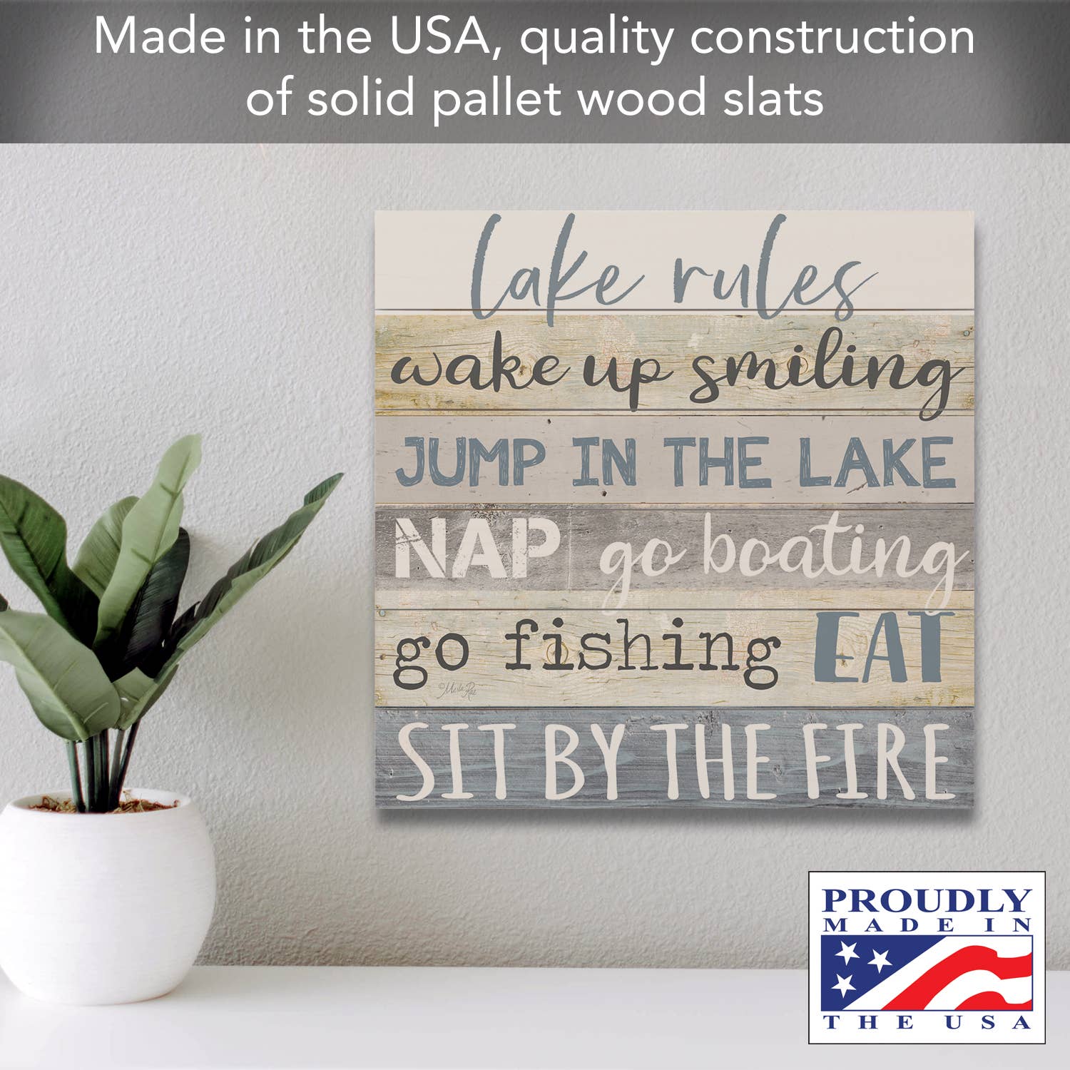 This rustic home design highlights the "Lake Rules" Decorative Slatted Pallet Wood Sign, which lists activities like waking up smiling, jumping in the lake, napping, boating, fishing, eating, and sitting by the fire. Made in the USA from solid pine wood slats, it's a perfect wall décor addition to your space near a plant.