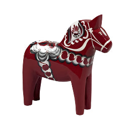 The Dala Horse from the Anniversary Series, Maria, by Grannas Olsson is a hand-carved red wooden piece showcasing intricate white, black, and gray patterns against a plain background.