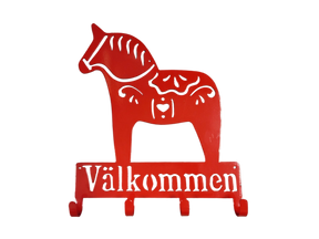 The Coat Hooks: Valkommen Dala Horse Sign is a red metal wall hook shaped like a Swedish Dala horse with "Välkommen" beneath—ideal as a unique entryway sign or for hanging coats.