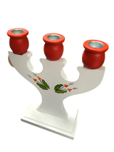 This hand-crafted Swedish candle holder features a white wooden design with a Dala horse, Kurbits floral accents, and holds 3 candles.