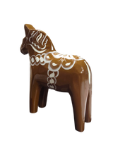 The Dala Horse: Swedish Dala Horse Brown with White Kurbits is a hand-carved, brown wooden figurine featuring white decorative patterns, inspired by the traditional Swedish folk symbol and handcrafted in Sweden.