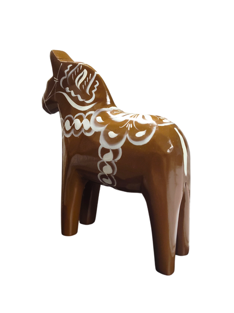 The Dala Horse: Swedish Dala Horse Brown with White Kurbits is a hand-carved, brown wooden figurine featuring white decorative patterns, inspired by the traditional Swedish folk symbol and handcrafted in Sweden.