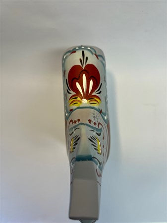 A close-up of the "Love Horse" (Karlekshast) Dala Horse, 13cm, features traditional Swedish floral patterns in red, yellow, black, and blue on a light background.