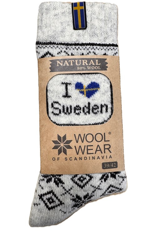 The product, Socks: Wool Wear - Natural 80% Wool I Love Sweden Swedish Flag, features a Scandinavian design, combining coziness with a wool blend and proudly displaying I ♥ Sweden alongside the Swedish flag on its label.