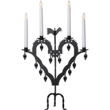 The Candelabra: Star Trading Metal Candlestick El-Tupp features a black metal, heart-shaped design with four lit white candles and decorative hanging elements, perfect for adding a warm Christmas atmosphere to your home.