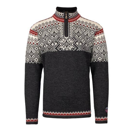 The Narvik Ski Sweater (312) in charcoal is made from 100% wool and showcases cream and red geometric designs inspired by Nordic winters. It features a quarter-zip neck and long sleeves.