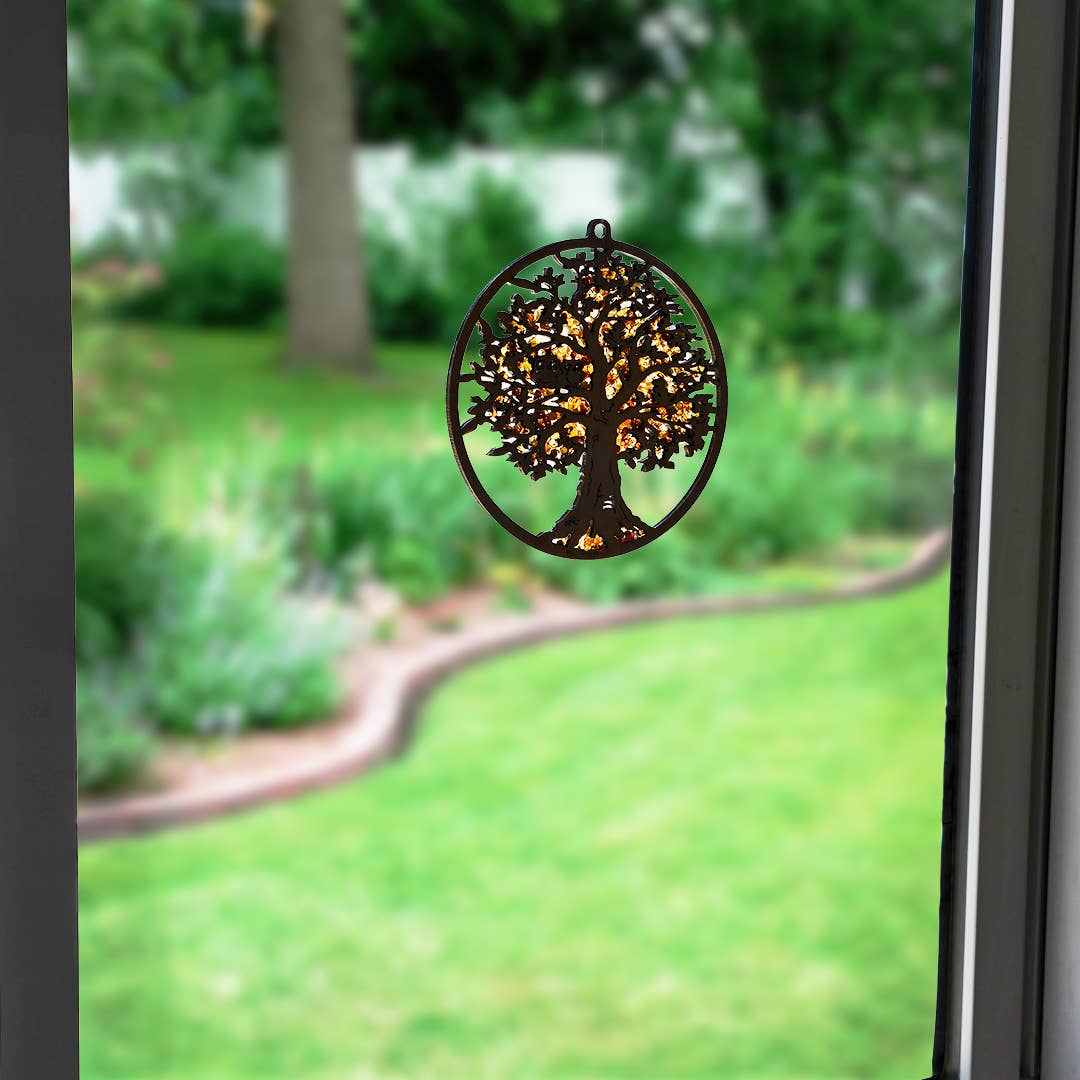 The Ornament: Tree of Life with Two Owls Amber Suncatcher casts captivating hues through the window, enchanting the view of the garden. This exquisite piece, adorned with Genuine Baltic Amber, transforms sunlight into vibrant shades.