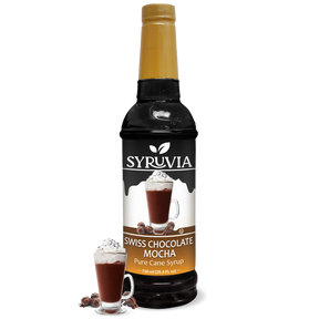 A 750 ml bottle of Syruvia Swiss Chocolate Mocha Syrup with Pure Cane Sugar is beside a glass of chocolate mocha topped with whipped cream and chocolate curls; this gluten-free syrup adds indulgence to drinks.