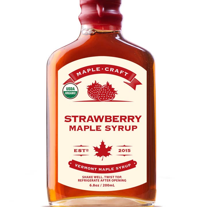 A 6.8 oz bottle of Summer Favorites Strawberry Maple Syrup features a red cap, detailed label, and USDA Organic logo. It is refined sugar-free, ideal for health-conscious sweet treat lovers.