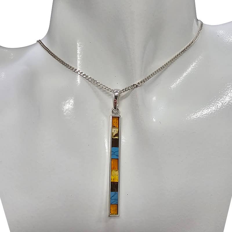 Sterling silver necklace with a long rectangular pendant featuring multi-color mosaic amber and pressed turquoise stones, elegantly displayed on a mannequin bust.