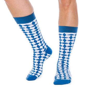 Person standing with one foot slightly forward, wearing blue and white socks featuring a geometric Swedish pattern.