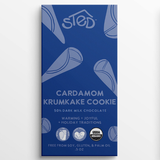 Blue wrapper with text: “Sted Cardamom Krumkake Cookie, 50% dark milk chocolate,” visible Scandinavian mention; symbols for organic, soy-free, gluten-free, palm oil–free.