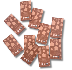 Caramel chocolate bars in brown packaging labeled “Caramel Crack” with organic certification symbols, arranged on a white background.