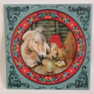 The 6" ceramic tile, "Fjord Horse with Tomte," shows a gnome in red sitting with a horse by candlelight in a stable, framed by rosemaling art—perfect Scandinavian holiday décor. Cork backing included.