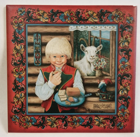 A blond child in traditional Nordic clothing holds food indoors; a goat stands outside the window. The scene is framed by a red Norwegian Rosemaling tile border.
