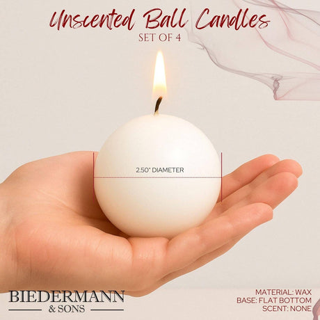 A hand holds a lit, peach ball candle (2.5" diameter) with a flat bottom; text specifies set of 4 decorative wax candles by Biedermann & Sons—Candles: Peach Ball Candles, 2.5" Diameter.