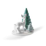 White ceramic deer figurine with two green stylized Christmas trees on a circular base.