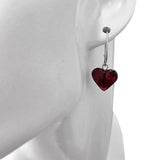 A close-up of a mannequin wearing Heart Cherry Amber Sterling Silver Earrings, featuring a dark red heart-shaped pendant.