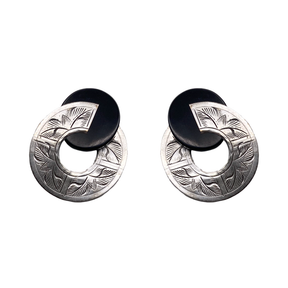 Broken Circle Post Earrings feature black discs that partially overlap matte silver rings engraved with a leaf pattern.