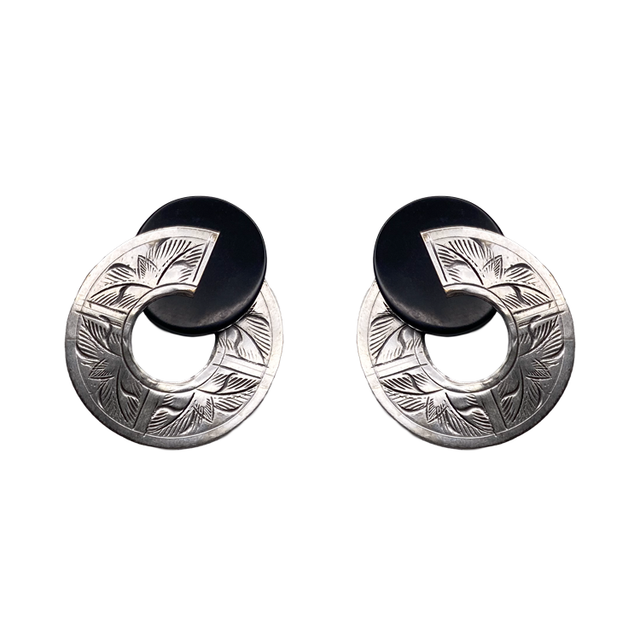 Broken Circle Post Earrings feature black discs that partially overlap matte silver rings engraved with a leaf pattern.