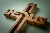 A 4" Olive Wood Cross Ornament from Bethlehem, laser-cut with "Jesus," beautifully crafted as a meaningful Holy Land keepsake.