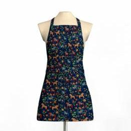 The mannequin features a Leksand Mini Swedish Dala Horse halter-style apron in dark blue with an enchanting pattern of orange cats and green leaves.